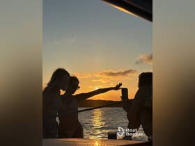 A group of friends captures a beautiful sunset while enjoying their time on a boat, creating unforgettable memories against a stunning backdrop.