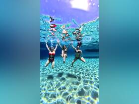 Three friends enjoy a fun underwater moment, showcasing the vibrant colors of the clear water — perfect for a memorable day of swimming and adventure.