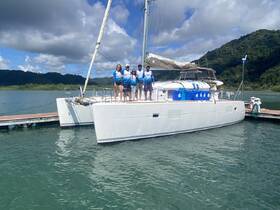 A cheerful group poses on the deck of a catamaran at the dock, ready for an exciting day on the water. Perfect for group outings and celebrations.