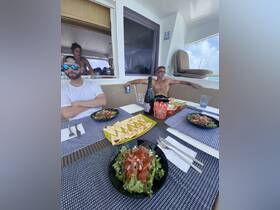 A delicious spread of salads and snacks is laid out on the dining table aboard a boat, perfect for enjoying a meal while cruising the waters.