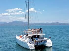 A lively group of friends celebrates aboard a catamaran, enjoying the sun and sea — perfect for unforgettable summer adventures.