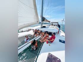 A lively group enjoys a fun day aboard a catamaran, relaxing and socializing with drinks in hand — perfect for a memorable boat party experience.