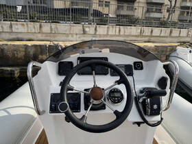 A detailed view of the helm and console of a boat, showcasing the steering wheel and various controls, perfect for navigating the waters.