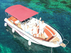 A cheerful group waves from their boat in crystal-clear waters, capturing the essence of a fun day on the water.