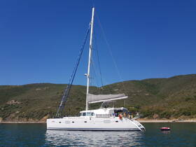 A stunning side view of a catamaran docked in calm waters, surrounded by lush green hills — perfect for exploring coastal destinations.
