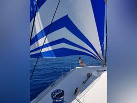 A woman enjoys the serene experience of sailing on a calm ocean, with a vibrant blue sail billowing in the wind — a perfect moment for sailing enthusiasts.