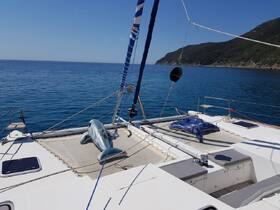 A serene view of a catamaran's deck, showcasing its spacious layout against a backdrop of calm blue waters — perfect for relaxing or sailing adventures.
