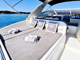 A cozy lounge area on a yacht featuring plush seating and neatly arranged towels, perfect for relaxation while enjoying the serene waters.