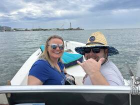 A cheerful couple enjoys a day on the water, showcasing smiles and a fun atmosphere aboard their boat.