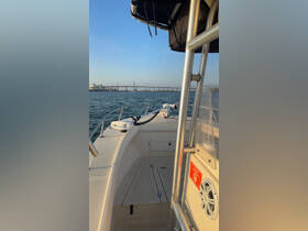 A view of the helm area inside a boat, showcasing the console and seating, perfect for navigating the waters.