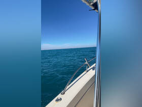 A clear view of the side of a boat cruising through vibrant blue waters, showcasing the serene beauty of a day on the water.