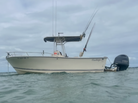 A sleek fishing boat named 'Challenger' is anchored in calm waters, showcasing its design and fishing gear — perfect for a day on the water.
