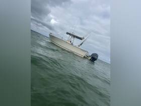 A sleek speedboat navigates through calm waters, showcasing its design and fishing gear, perfect for a day on the water.