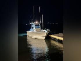 A fishing boat docked at night, illuminated by lights reflecting on the calm water — perfect for evening fishing trips or nighttime adventures.