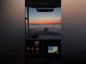 A view from the helm of a boat at sunset, showcasing the navigation console and instruments, perfect for those who enjoy boating adventures.