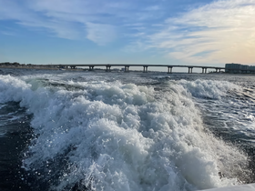 A view of choppy waters with waves and a distant bridge, capturing the essence of a boating experience.