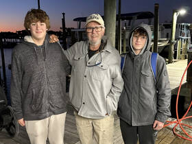 A family poses together at the dock during sunset, capturing a memorable moment before their boating adventure.