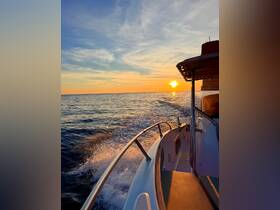 A stunning sunset view from the deck of a boat, showcasing the tranquil waters and vibrant sky — perfect for evening cruises.