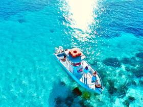 Aerial view of a group enjoying a day on a boat in stunning turquoise waters, capturing the essence of a perfect summer getaway.