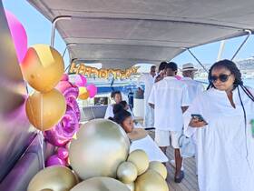 A lively birthday celebration aboard a yacht, featuring guests in white attire and festive decorations, creating a perfect atmosphere for memorable moments on the water.