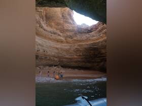 A group of friends enjoys a day at the beach inside a stunning cave, creating unforgettable memories in a picturesque setting.