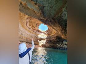 A stunning view from inside a cave, showcasing a group enjoying the beach outside — a perfect destination for adventure seekers exploring coastal wonders.