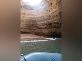 A stunning view of a secluded beach nestled within a rocky cave, showcasing the natural beauty of the coastline — perfect for exploring hidden gems on a boat trip.