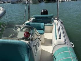 Interior view of a well-maintained boat helm and seating area, showcasing the comfortable turquoise upholstery and console, perfect for a day on the water.