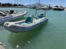 A sleek inflatable boat docked in a marina, showcasing its design against a backdrop of other vessels and clear waters.