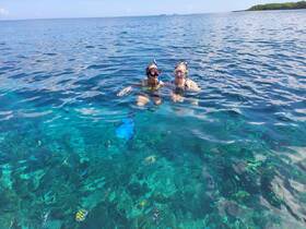 A couple enjoys snorkeling in crystal-clear waters, surrounded by vibrant marine life — a perfect adventure for ocean lovers.