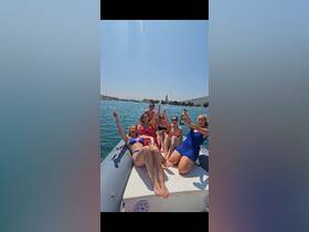 A lively group of friends celebrates on a boat, raising champagne glasses under the sun — perfect for bachelorette parties or summer outings on the water.