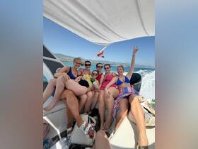 A lively group of friends enjoys a fun day on the boat, celebrating together with smiles and laughter — perfect for unforgettable summer adventures.