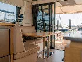 Interior view of a modern boat cabin featuring comfortable seating and a helm area, perfect for relaxing or navigating on the water.