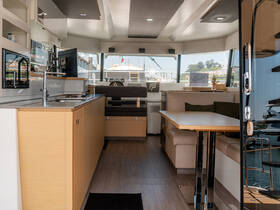 A modern and spacious interior of a boat featuring a well-equipped kitchen and comfortable seating area, perfect for relaxing while on the water.