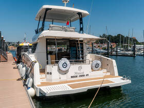 A sleek yacht named 'Muscat' docked at a marina, showcasing its elegant design and spacious deck, perfect for luxury outings on the water.