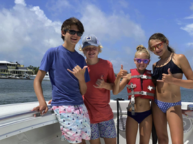 A cheerful group of kids poses on the boat, showcasing their excitement for a day of fun on the water. Perfect for family outings and adventure-filled trips.