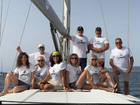 A cheerful group poses on the deck of a sailboat, showcasing their camaraderie and love for sailing — perfect for memorable adventures on the water.