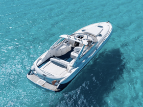 A stunning aerial view of a sleek yacht cruising through crystal-clear turquoise waters, perfect for luxury charters and island adventures.