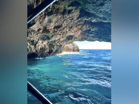 A stunning view from inside a cave, showcasing the vibrant blue ocean and rocky coastline — a perfect representation of coastal adventures.