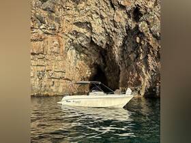 A serene view of a boat anchored near a rocky cave, showcasing the beauty of coastal landscapes and perfect for exploring hidden gems on the water.