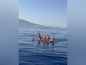 A group of friends enjoys a fun day on the water, paddleboarding and soaking up the sun in a serene ocean setting.