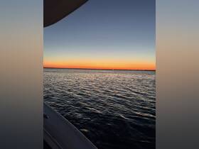 A serene sunset view over calm waters, captured from the deck of a boat — perfect for those seeking tranquility on the water.