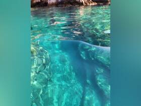 An unclear image of turquoise water with reflections, lacking identifiable subjects or context.