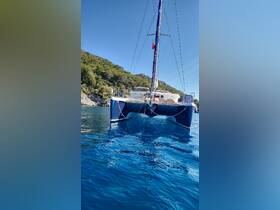 A stunning view of a catamaran anchored in calm waters, surrounded by lush greenery — perfect for serene sailing adventures.