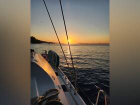 A serene sunset view from the deck of a yacht, showcasing the tranquil waters and distant mountains — perfect for evening cruises.