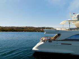 A stunning Azimut yacht docked in serene waters, showcasing its elegant design against a picturesque backdrop of lush hills.