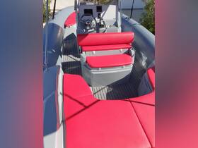 Interior view of a sleek boat helm featuring vibrant red seating and modern controls, perfect for a comfortable and stylish boating experience.