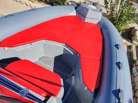 Interior view of a sleek boat featuring comfortable red seating and a well-designed helm area, perfect for relaxing on the water.