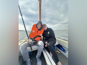 A happy couple enjoys a fishing trip on a boat, showcasing a perfect day on the water together.