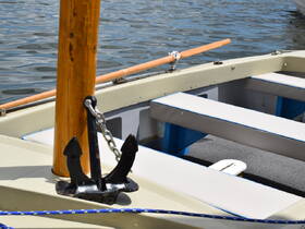 A close-up view of the interior of a boat featuring seating and an anchor, showcasing the vessel's design and functionality.